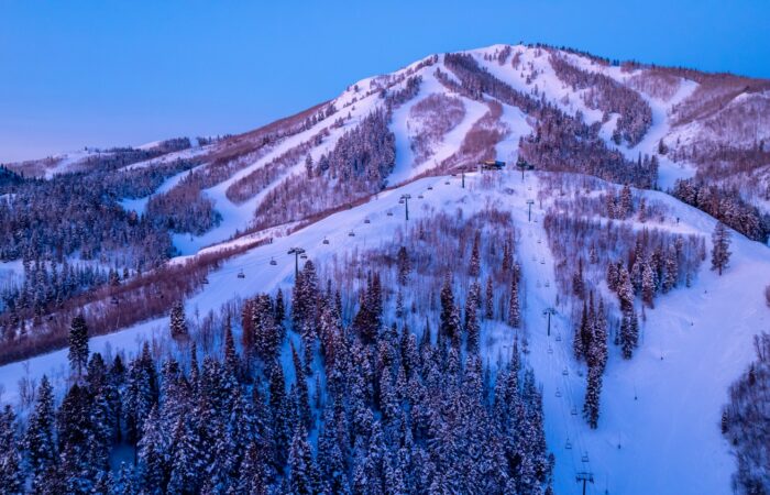 A chairlift with a scenic snow covered mountain backdrop at Deer Valley