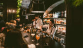 Guests sitting at the bar in the living room of Hotel Jerome, Aspen USA