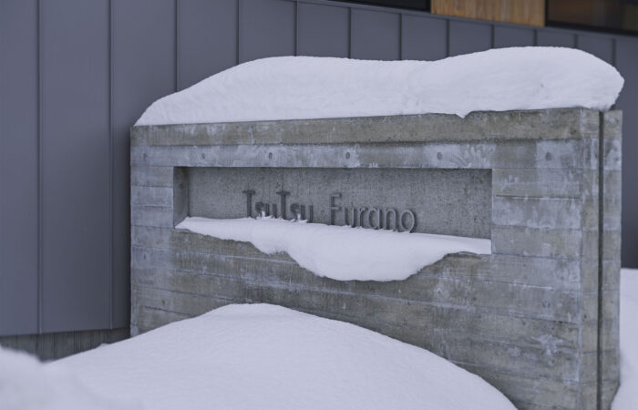 Snow-covered Tsu Tsu Furano accommodation sign at entrance in Furano Japan
