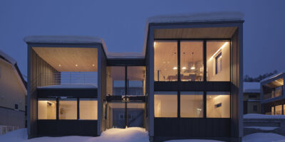 Tsu Tsu Furano accommodation exterior at night surrounded by snow in Furano Japan