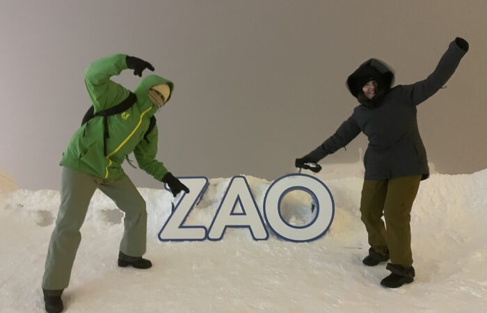 Skiers posing beside the Zao sign on the ski slopes in Zao Onsen Japan