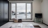 Bedroom with snowy window views at Shochikubai accommodation Furano
