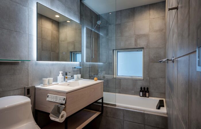 Bathroom with bath, shower and toilet at Arthouse Apartments Furano