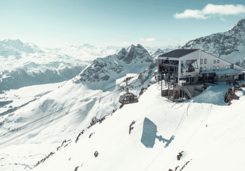 Luxury St. Moritz accommodation with panoramic views of snow-covered mountains in the Swiss Alps.