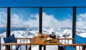 A roof top dining setting overlooking snow covered mountains at Val Thorens France