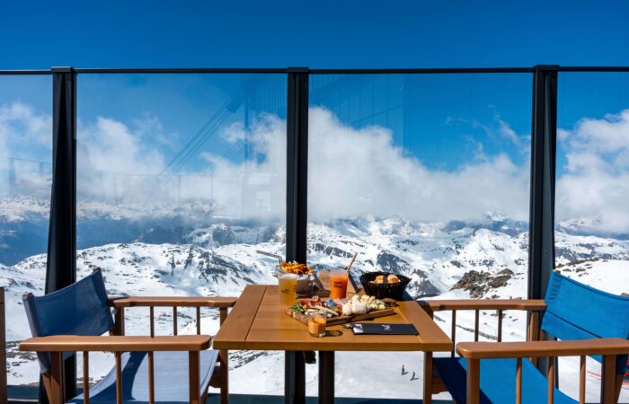 A roof top dining setting overlooking snow covered mountains at Val Thorens France