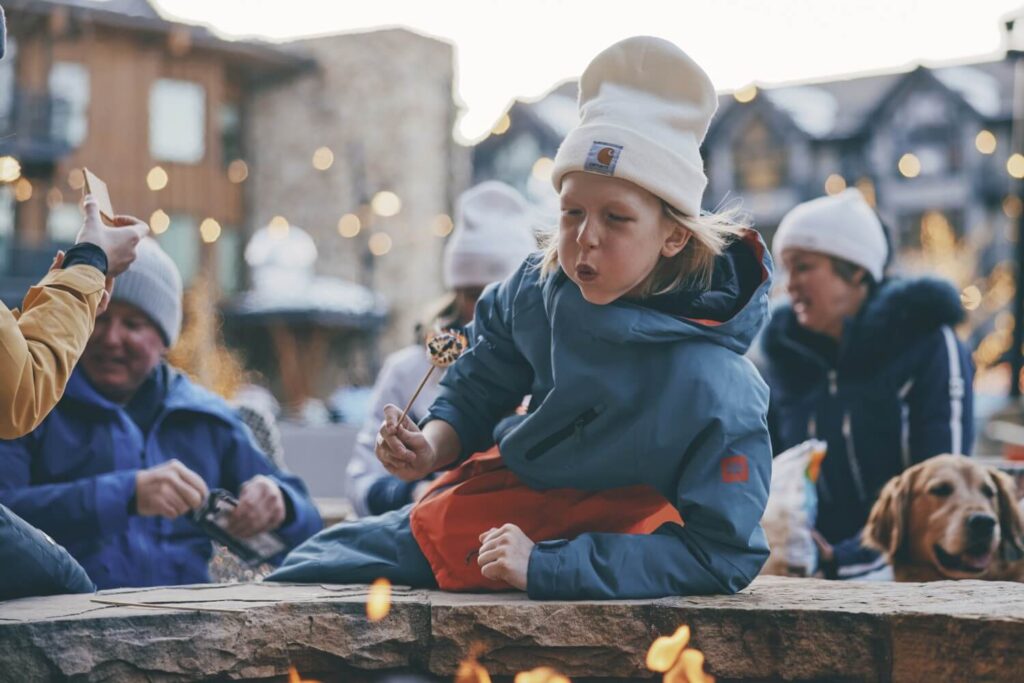 a boy toasts marshmallows over an open fire at Snowmass Village