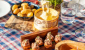 A guest at a table set with food from BeefBar restaurant at Hotel Le Coucou Meribel France