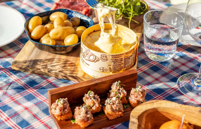 A guest at a table set with food from BeefBar restaurant at Hotel Le Coucou Meribel France