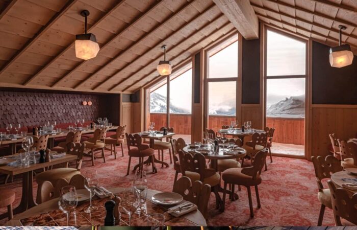 An empty restaurant interior view set for dining at Hotel Le Coucou Meribel France