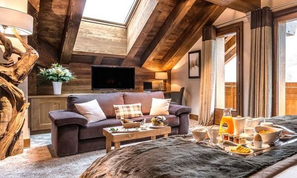 Bed and living area of luxury hotel room at Hotel Le Kaila Meribel France