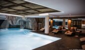 Guests lounging by indoor pool area at Nuxe spa Hotel Le Kaila Meribel France