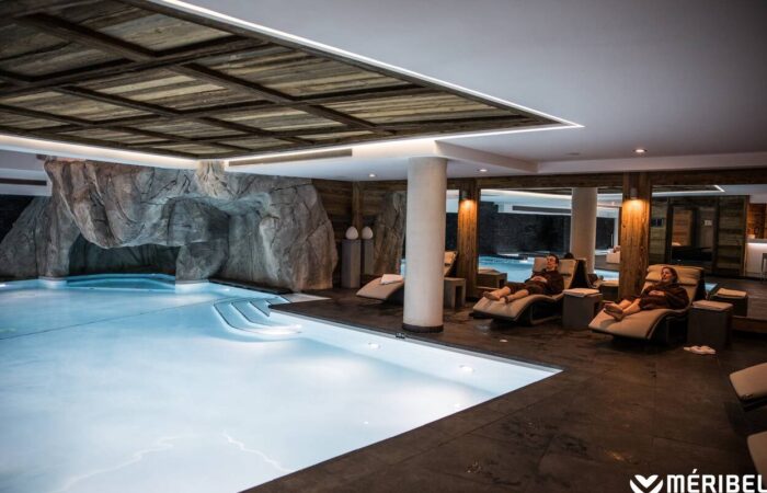 Guests lounging by indoor pool area at Nuxe spa Hotel Le Kaila Meribel France