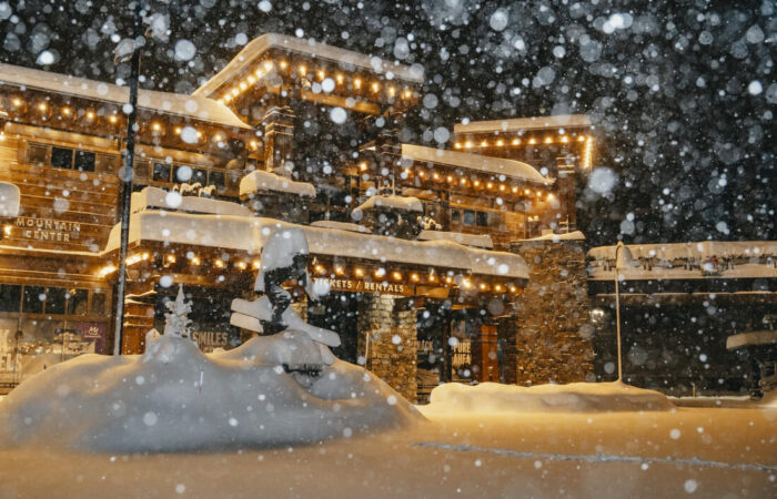 External night view of The Village Lodge Mammoth with new falling snow