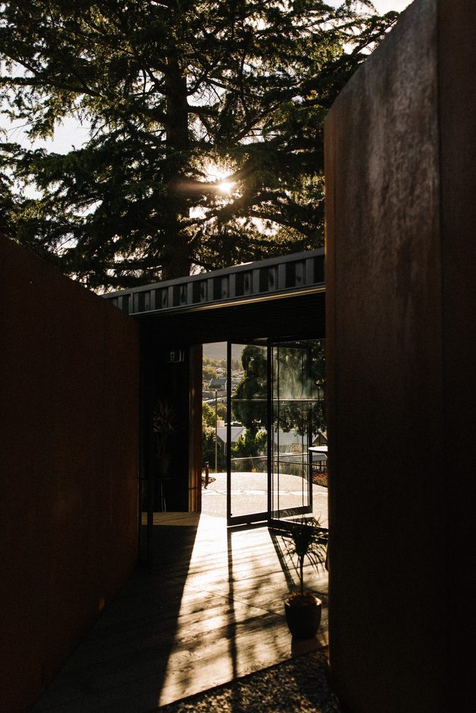 An entry way framed by trees at Bathe by Aluume Queenstown