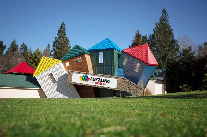 Colourful angled towers behind a Puzzling World sign